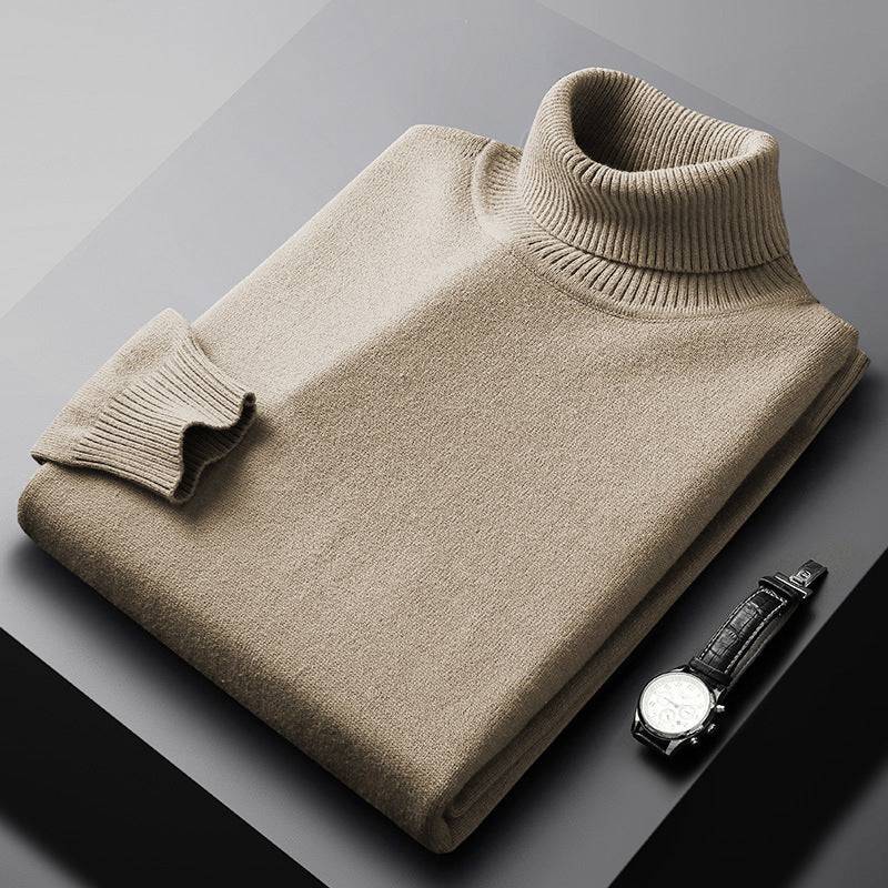 Beige high collar warm chenille sweater neatly folded next to a wristwatch on a gray surface