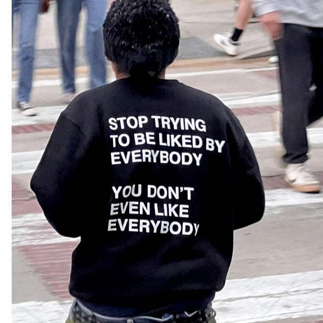 Men's and women's black sweatshirt with bold white slogan text and drawstring hood, casual unisex streetwear hoodie