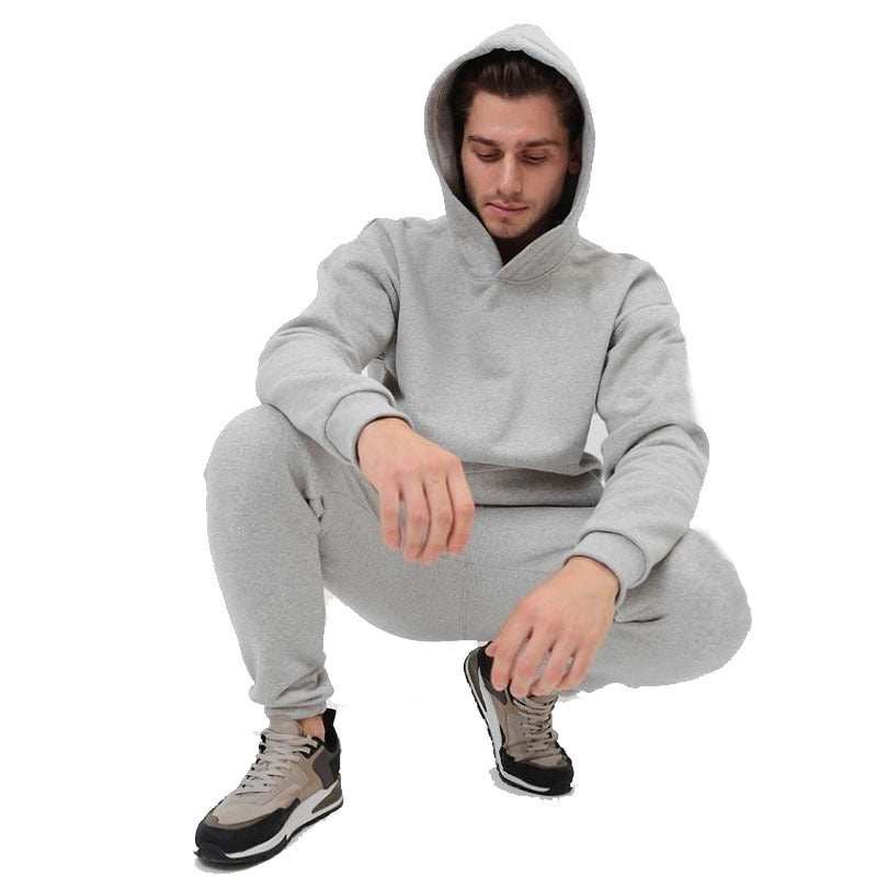 Man wearing gray hoodie two-piece set with matching joggers and sneakers, casual streetwear style