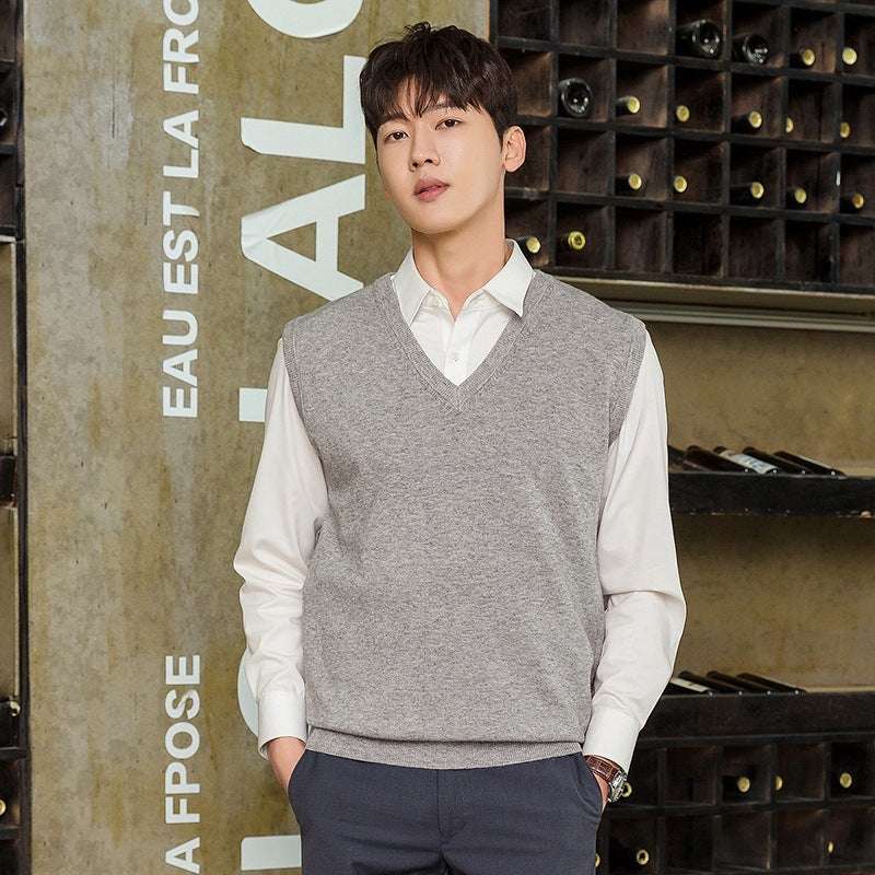 Man wearing grey knitted mens vest pullover over white shirt in casual indoor setting