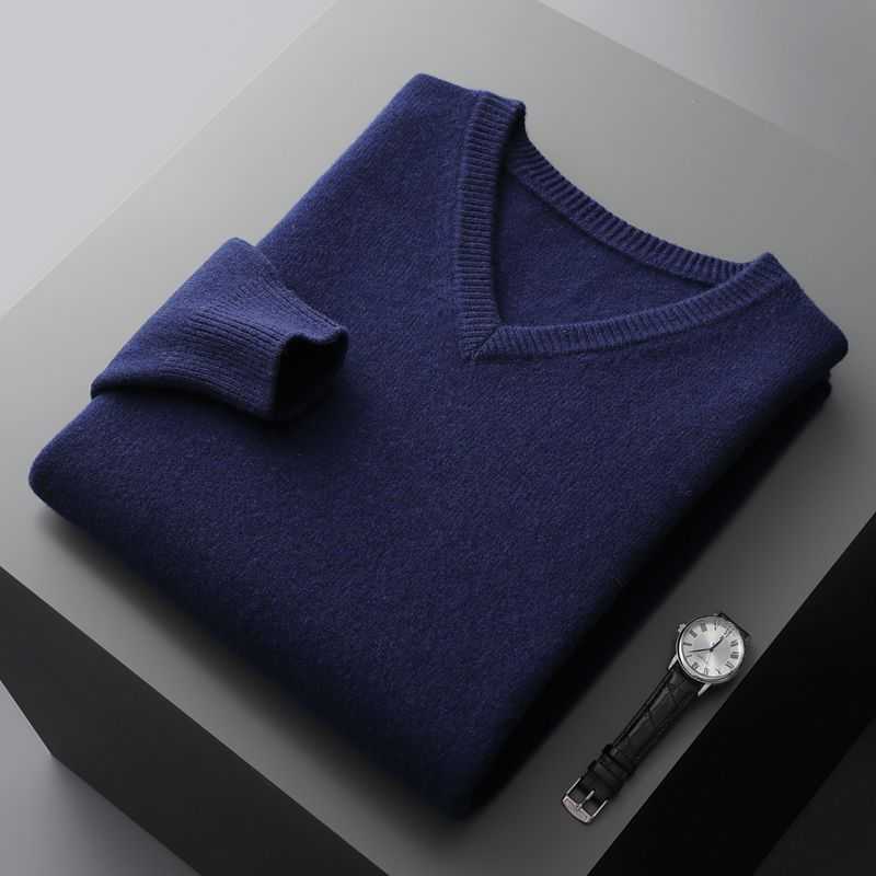 Business casual light luxury men's navy blue V-neck undershirt folded with a black leather strap wristwatch on a gray surface