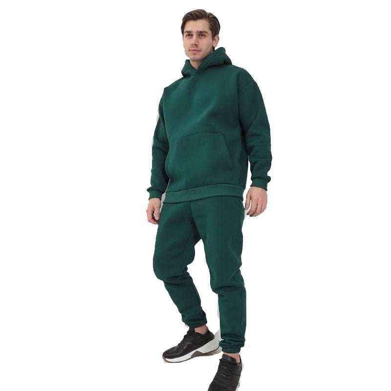 Man wearing dark green hoodie two-piece set with matching joggers and black sneakers