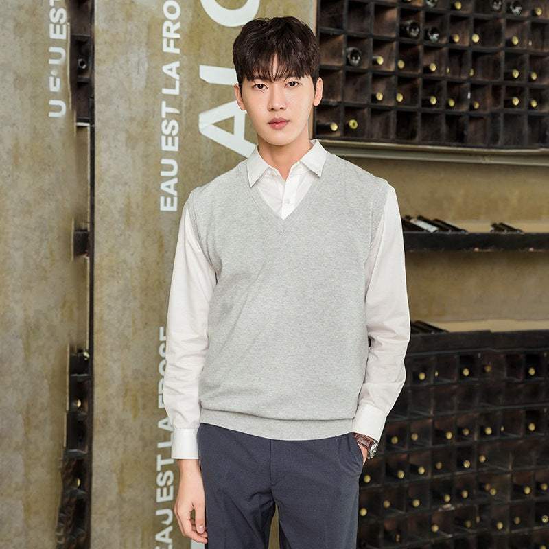 Man wearing a light gray men's vest pullover over a white shirt, styled for casual autumn and winter wear.