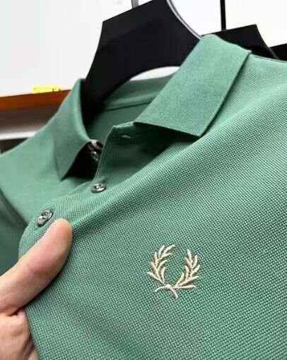 Men's lapel half sleeve polo shirt in green with embroidered logo and buttoned collar on hanger