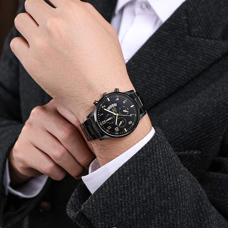 Men's multifunctional black quartz watch with stopwatch and date display on wrist, styled with formal suit
